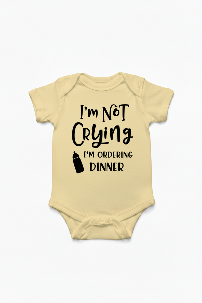 Banana color baby onesie with text 'I'm Not Crying I'm Ordering Dinner' on a white background