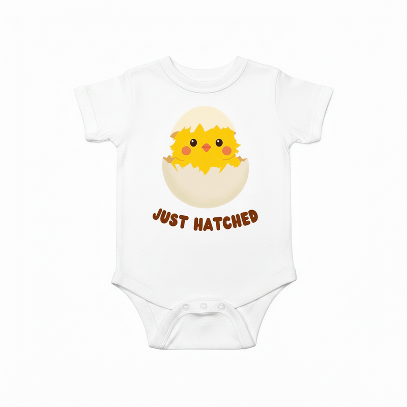 White onesie with a baby chick hatching and 'Just Hatched' text on a white background